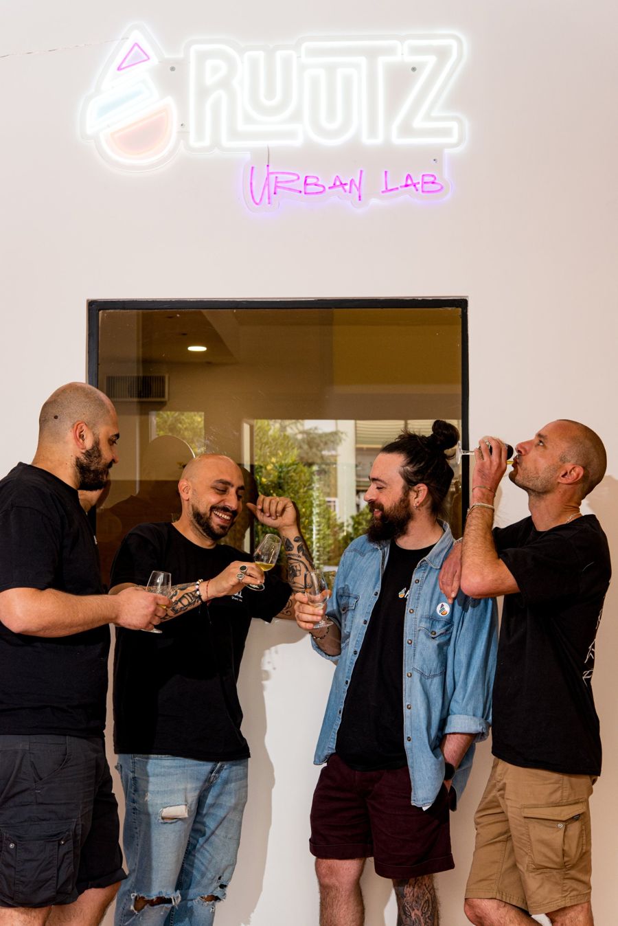 Brindisi sotto l’insegna al neon Ruutz Urban Lab